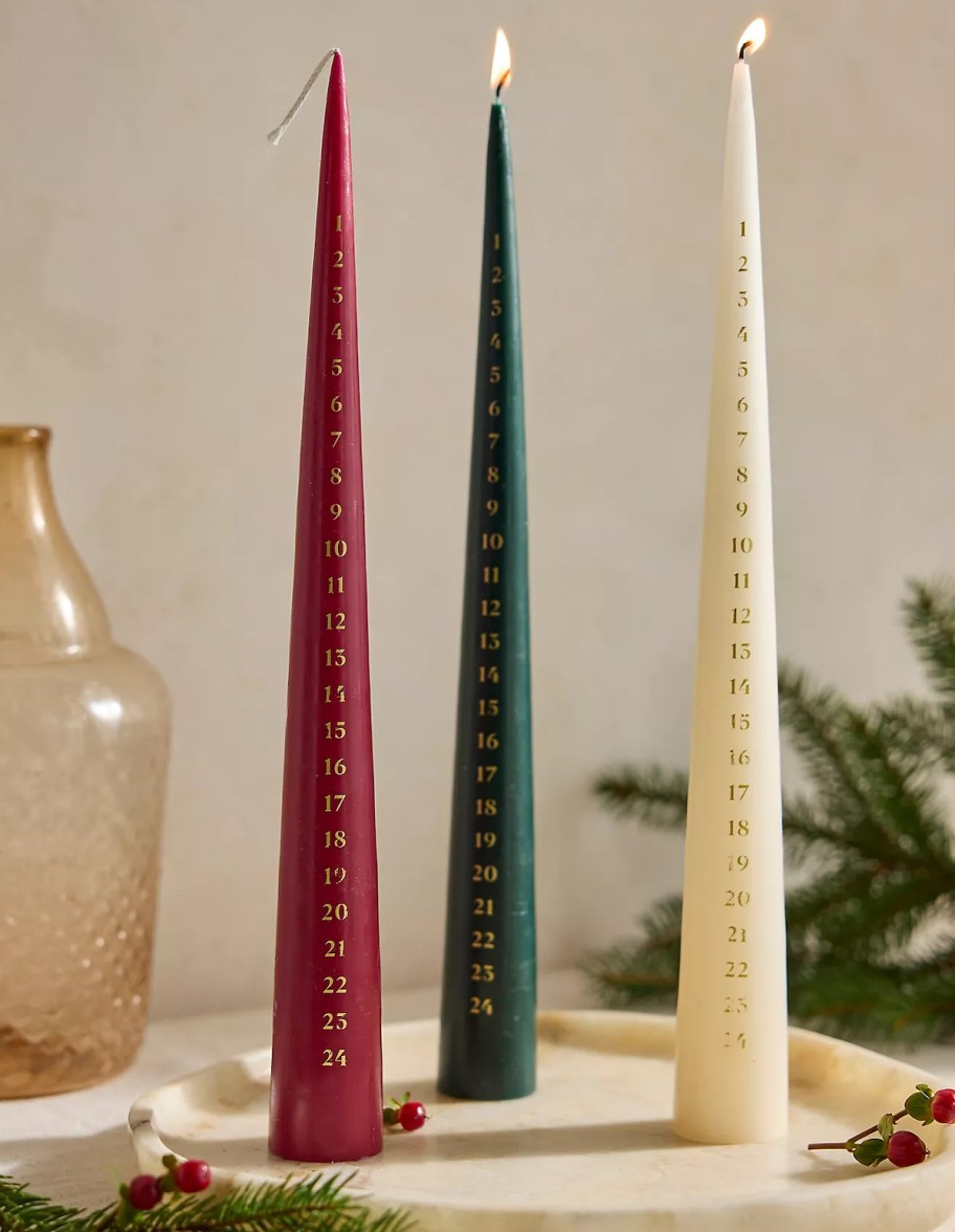 Red green and white advent calendar candles on table