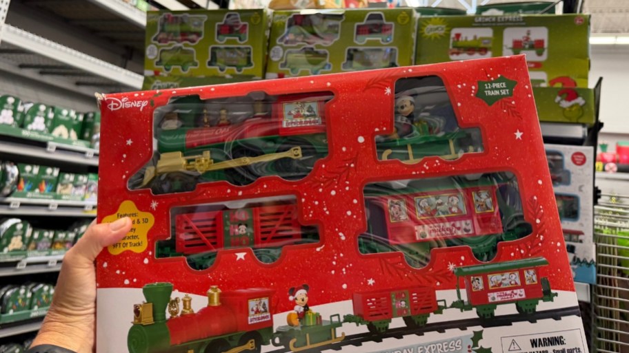 a hand holding a disney train set