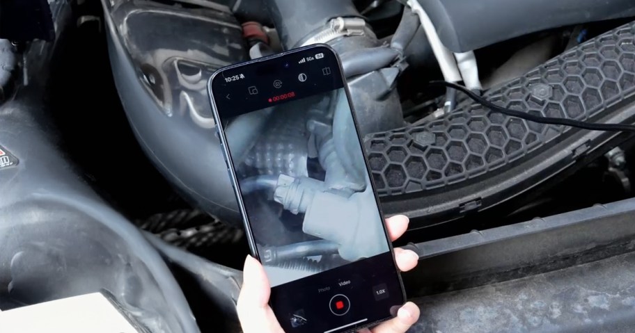 person using an endoscope to work on their car