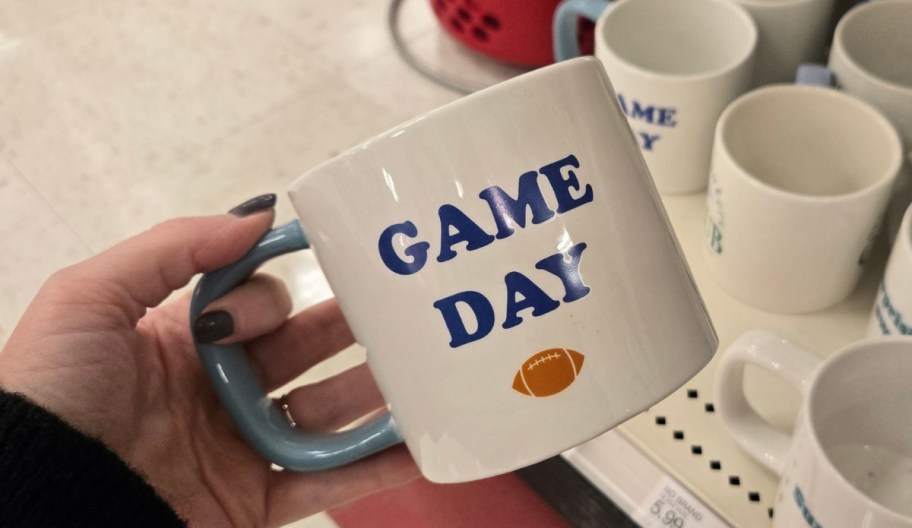 a womans hand holding a coffee mug