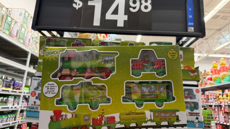 a hand holding a grinch train set