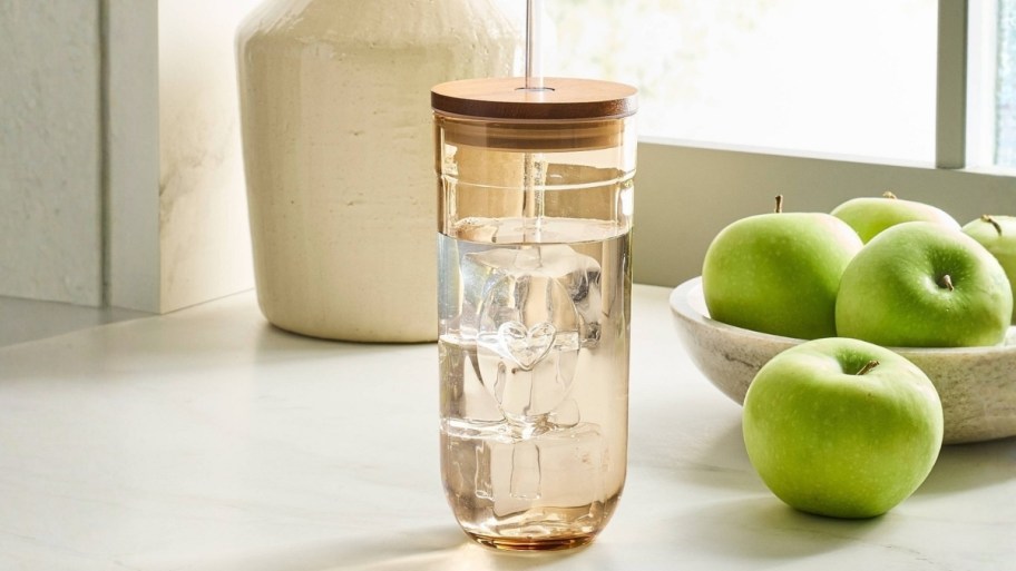 a brown glass heart tumbler with lid and dstraw.