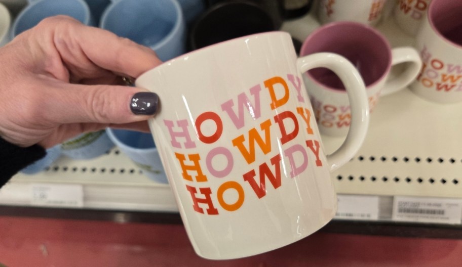 a womans hand holding a coffee mug