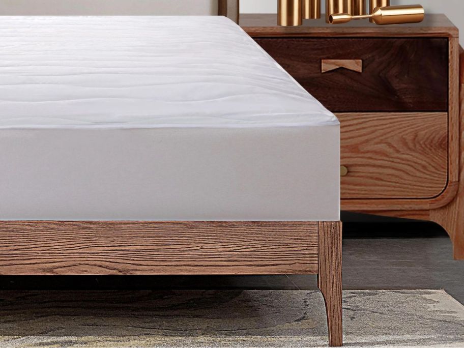 bed with white mattress pad on it