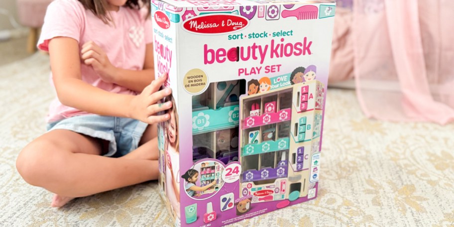 girl sitting behind beauty kiosk toy box