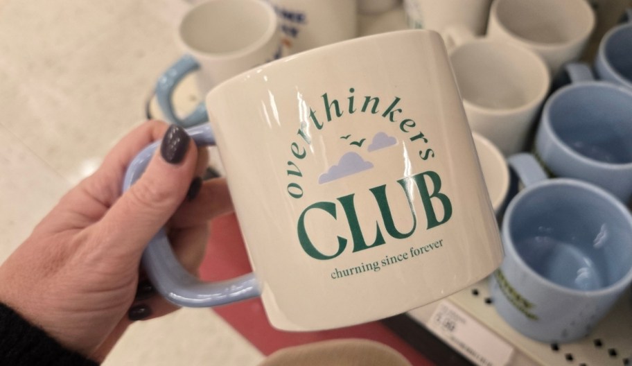 a womans hand holding a coffee mug