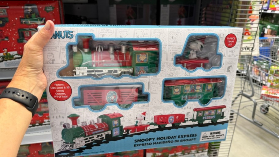 a hand holding a peanuts train set