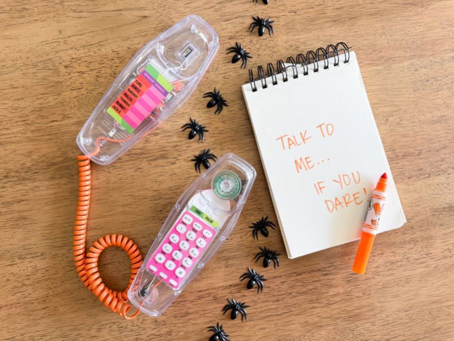 retro translucent phone off the hook on the floor next to s note saying "talk to me...if you dare!"