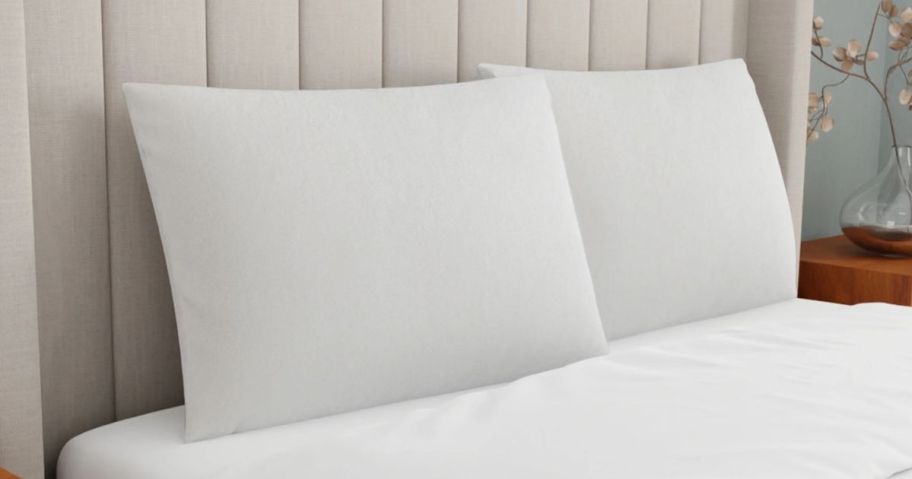 two memory foam pillows with white cases on bed