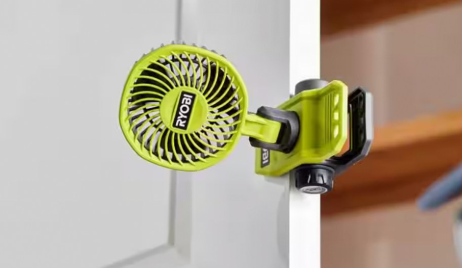 green fan clamped onto door frame