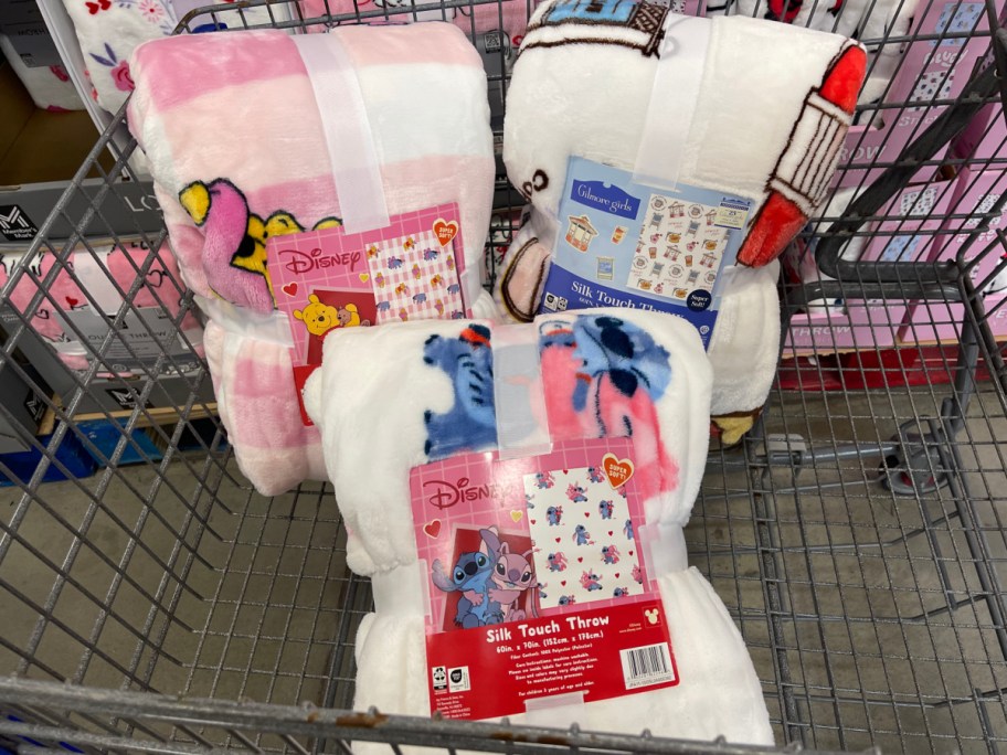 Three Valentine's Day throw blankets in a cart at Sam's Club.