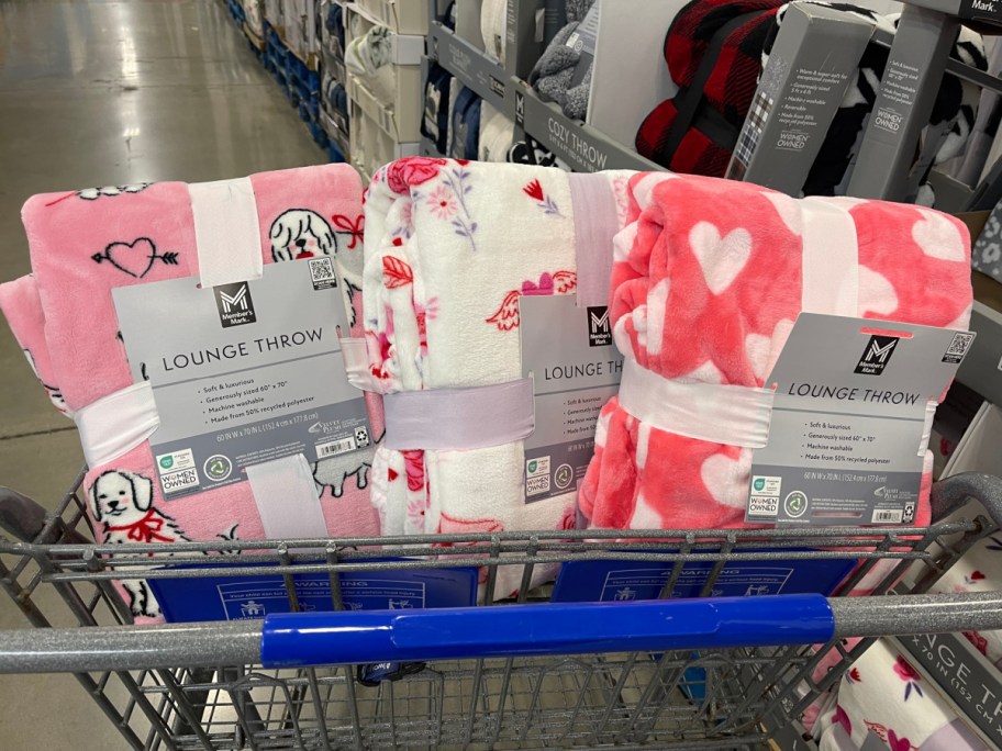 Three Valentine's Day throw blankets in a cart at Sam's Club.