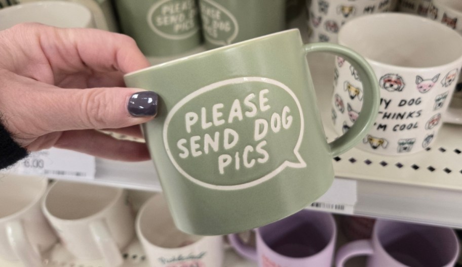 a womans hand holding a coffee mug