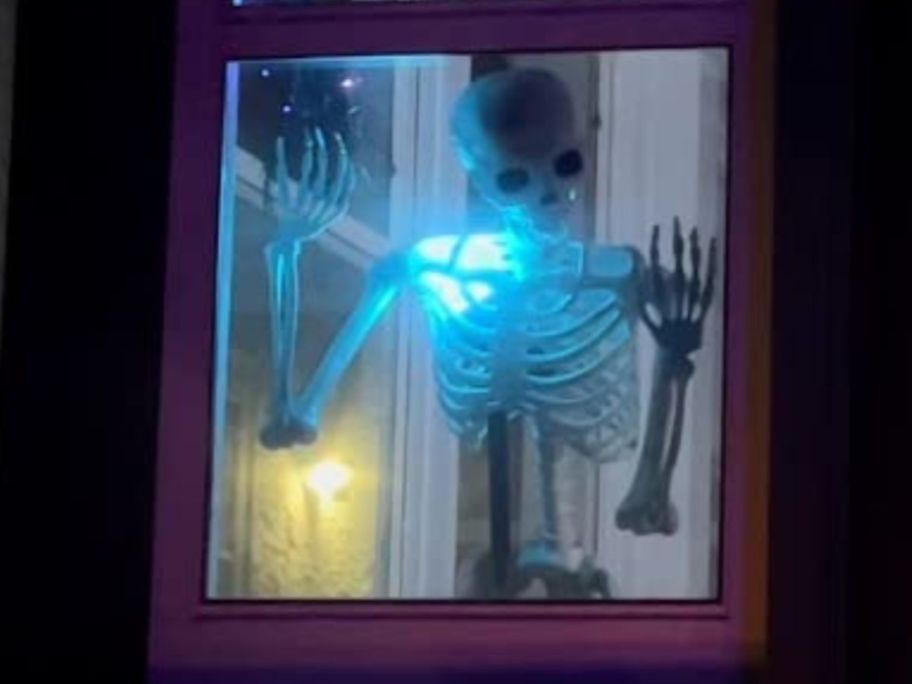 skeleton inside window with blue light on it