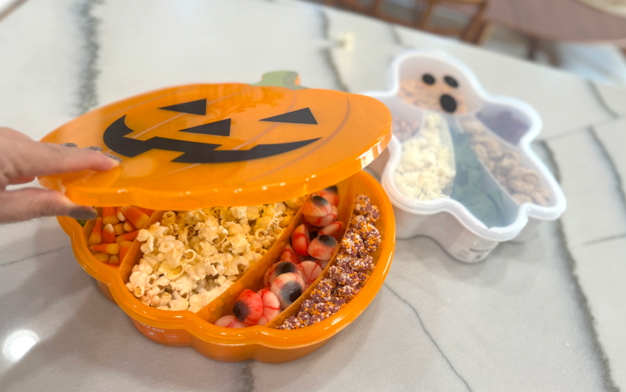 hand opening pumpkin snackle box on kitchen 