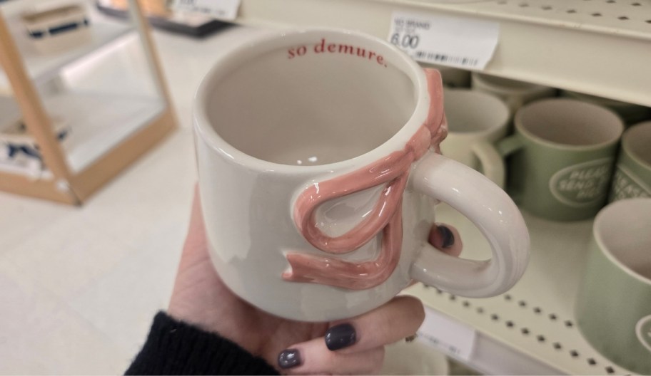 a womans hand holding a coffee mug