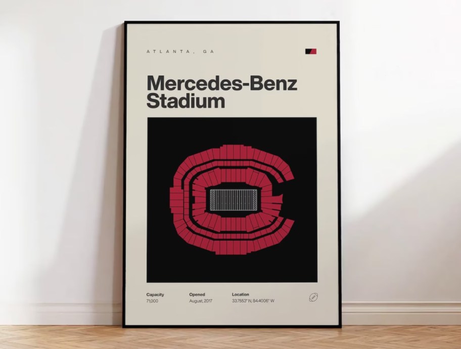 mercedes benz stadium artwork in frame leaning on white wall
