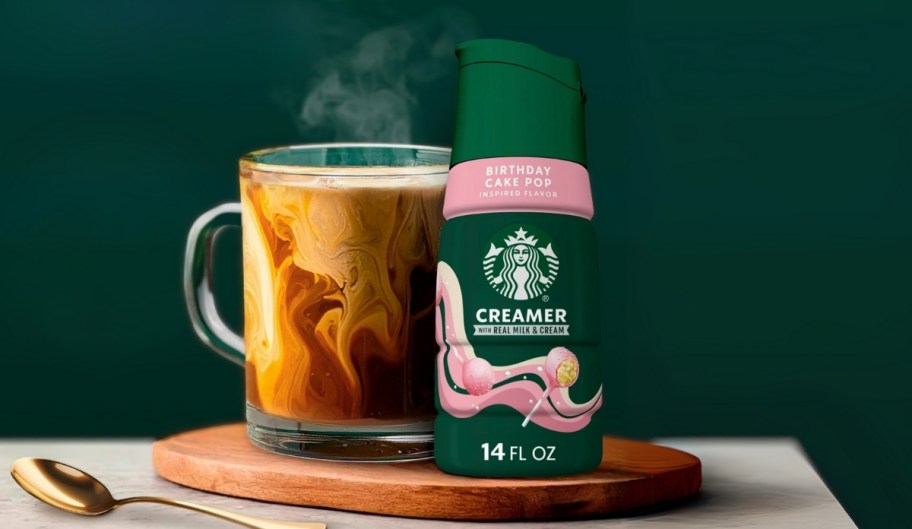 a bottle of starbucks dairy creamer next to a cup of coffee