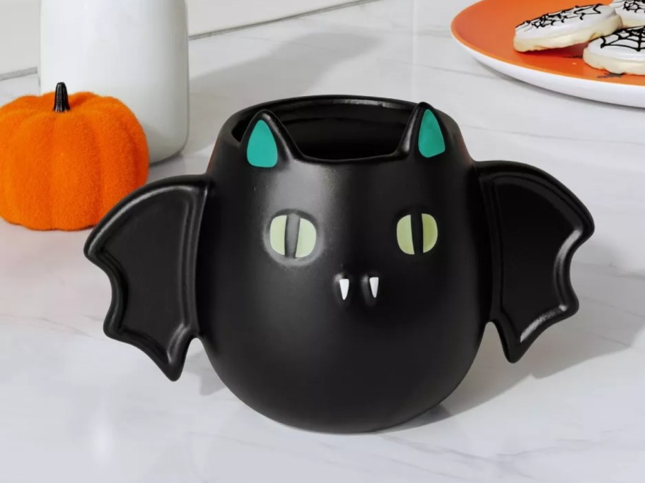 a bat shaped Halloween mug on a kitchen counter