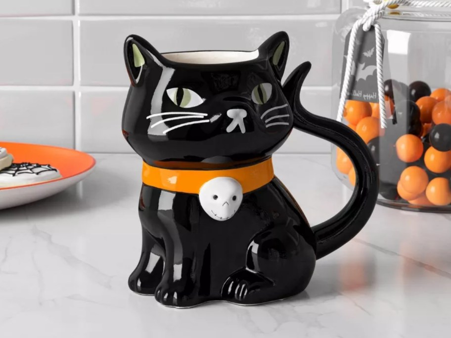 a coffee mug shaped like a black cat on a kitchen counter