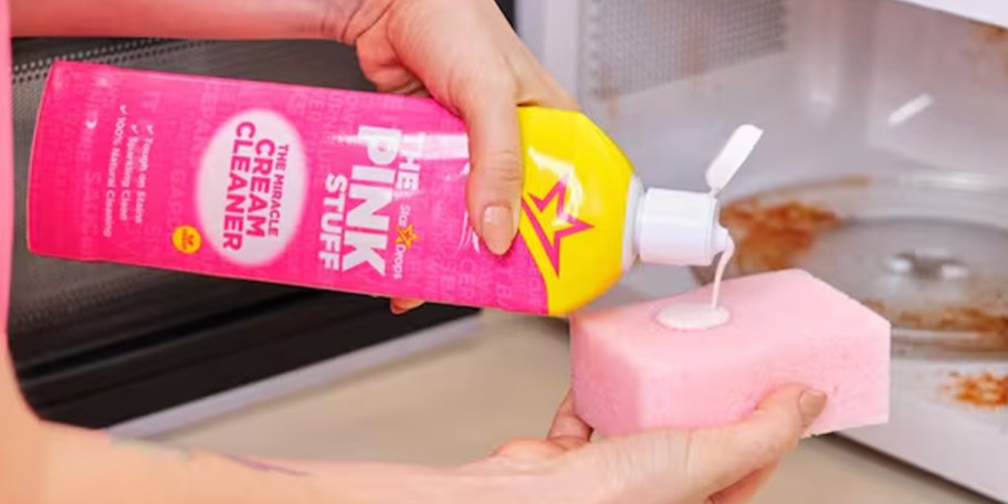person pouring pink stuff cleaner onto sponge