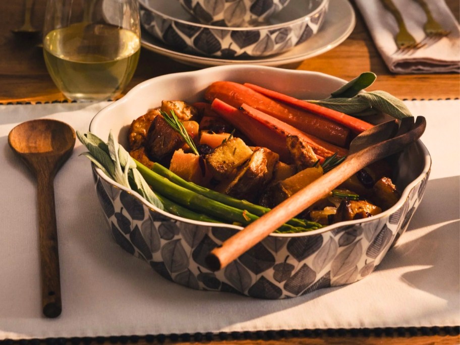 a serving bowl with a wooden fork and spoon on a table