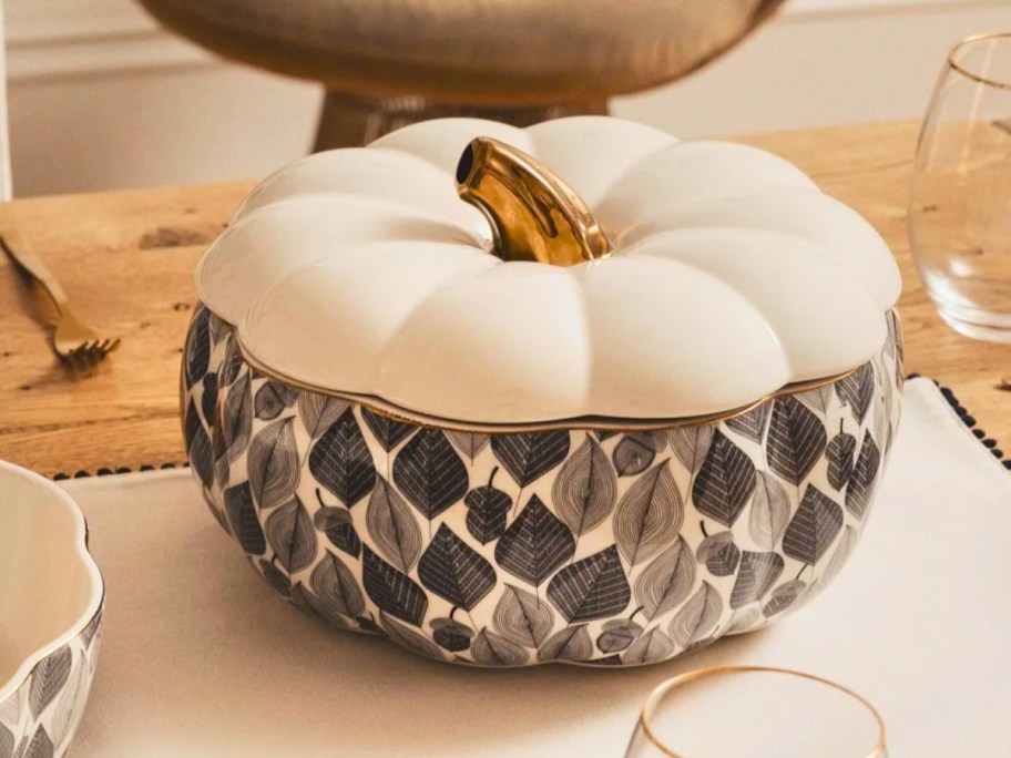 a large pumpkin shaped soup tureen on a table