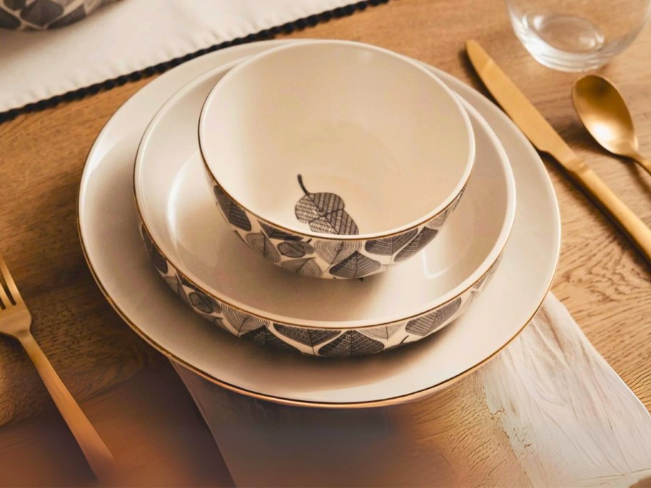 a cereal bowl, low bowl, and plate with a leaf pattern on a table