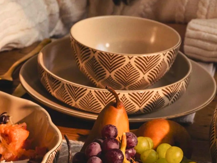 a cereal bowl, low bowl, and plate with a leaf pattern on a table