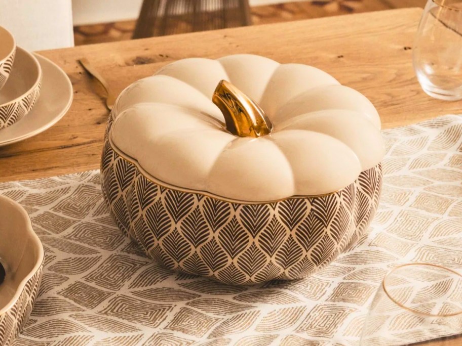 a large pumpkin shaped soup tureen on a table