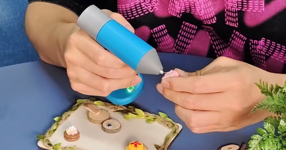 person using a glue gun while crafting 