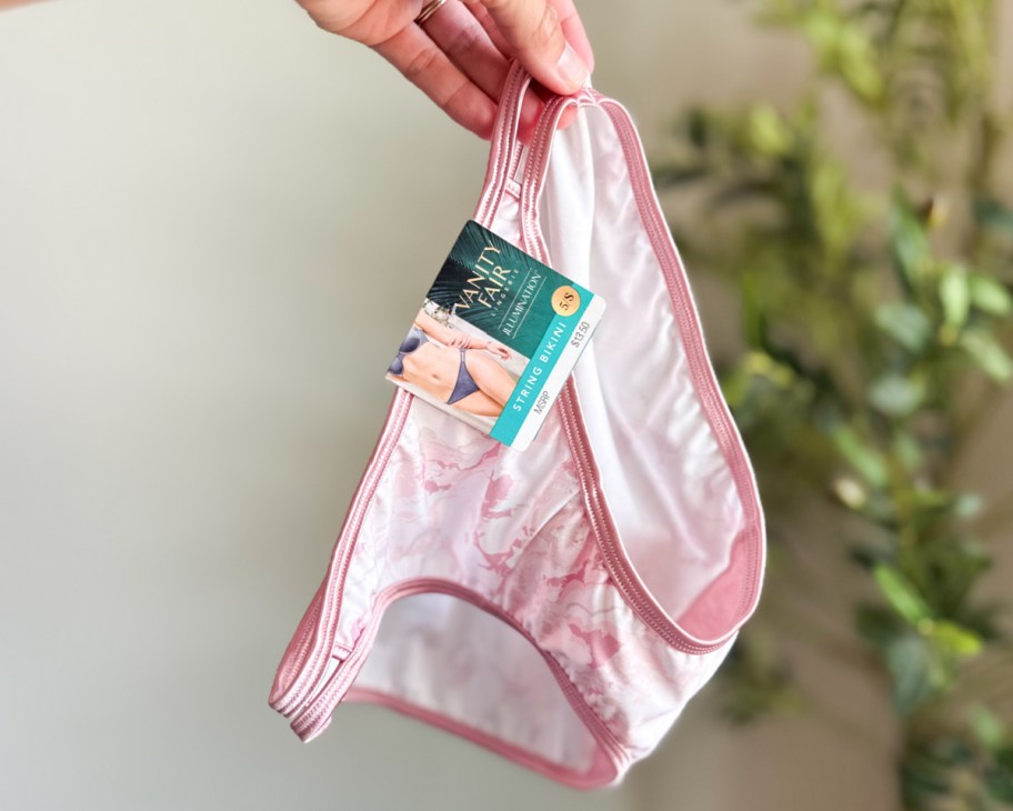 hand holding pink underwear in air