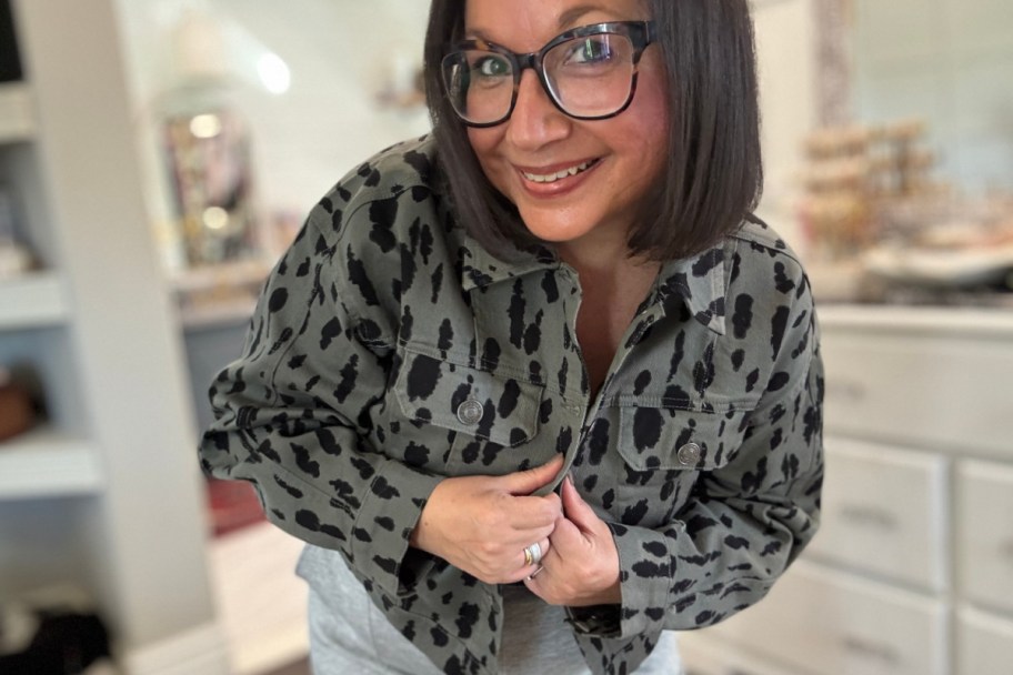 woman holding buttons on denim grey and black leopard trucker jacket