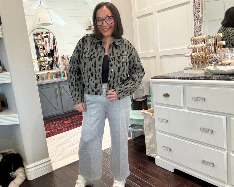 woman in bathrom with grey cropped pants and grey and black leopard cropped jacket