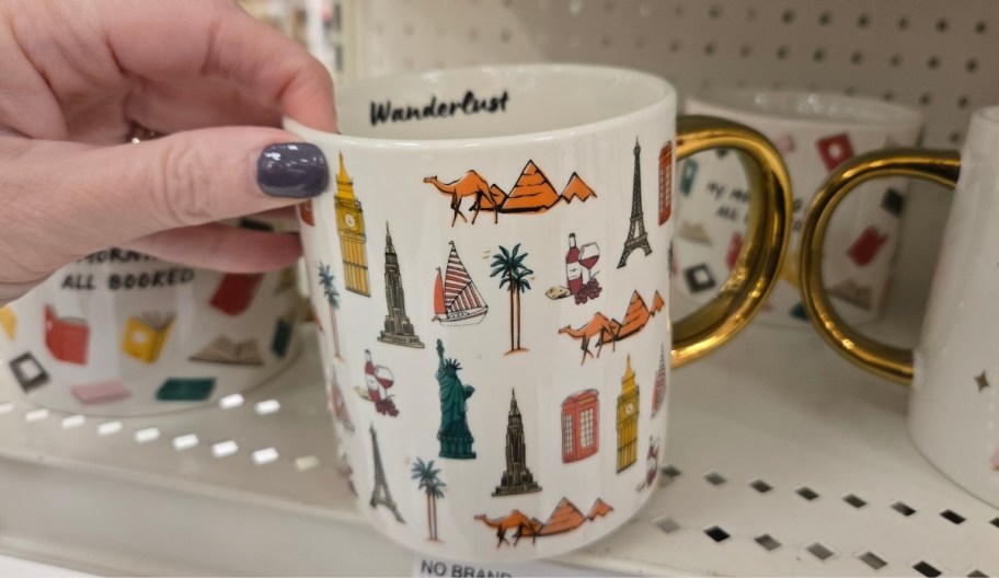 a womans hand holding a coffee mug