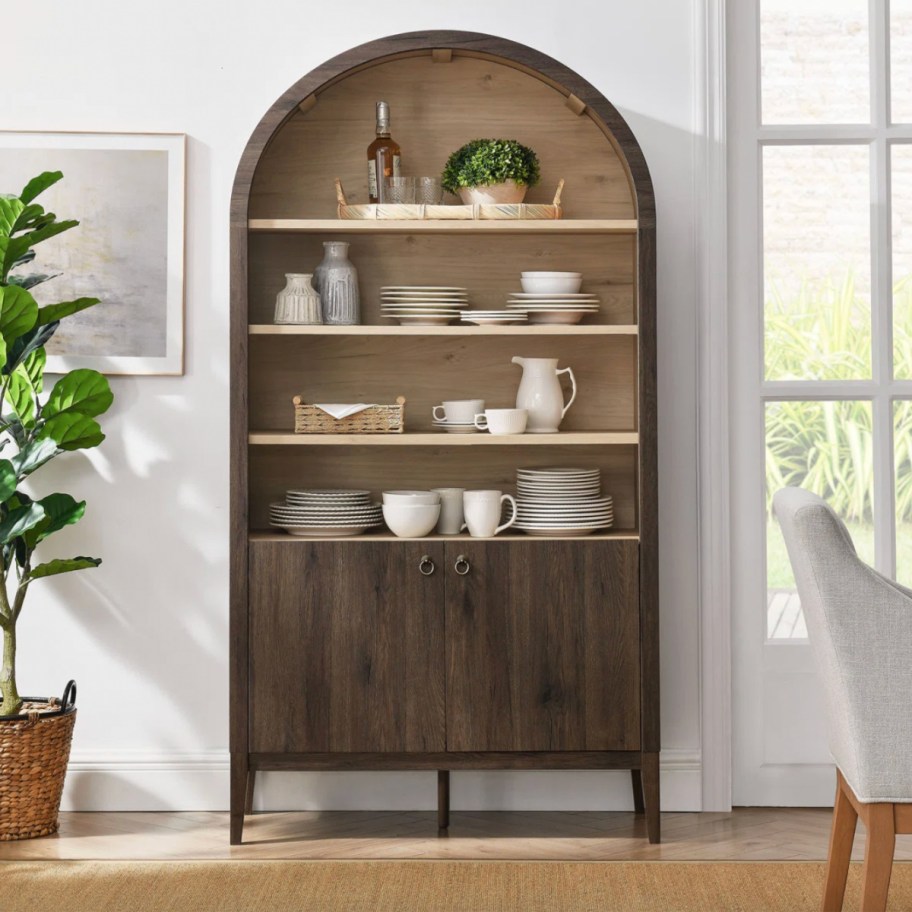 dark brown arched storage cabinet decorated