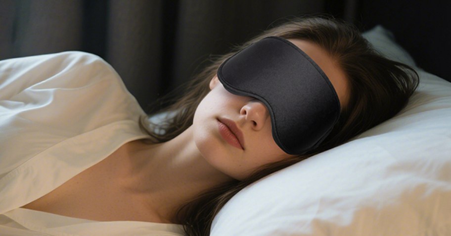 woman laying in bed wearing a black sleep mask