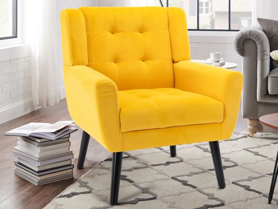yellow accent chair displayed in living room with books next to it 