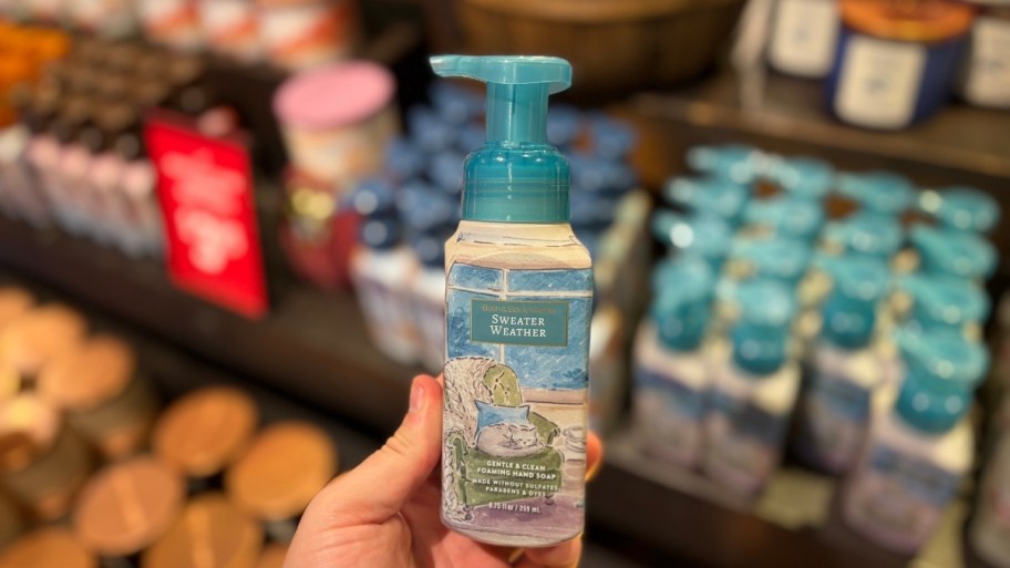 a hand holding a bottle of foaming hand soap