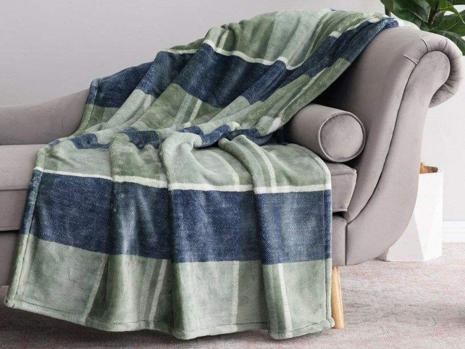 a green and blue plaid throw draped over a chaise lounge