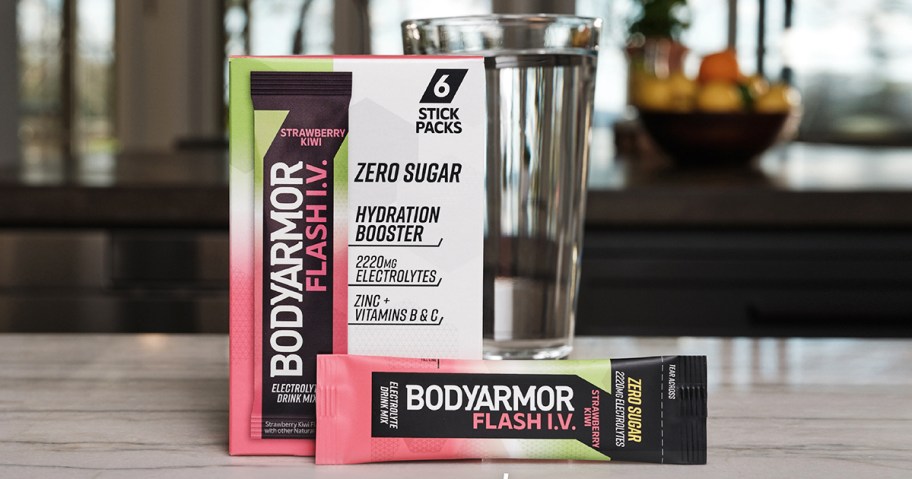 box of Bodyarmour electrolyte packets in front of a glass of water