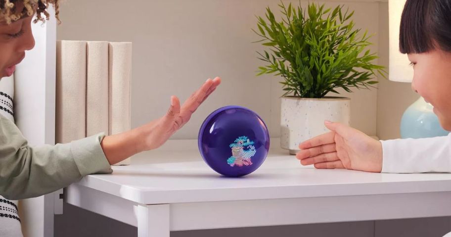 Two kids playing with a Bitzee Hamster