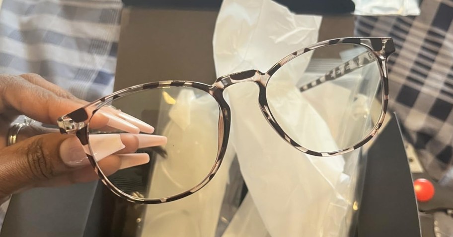 hand holding up a pair of glasses