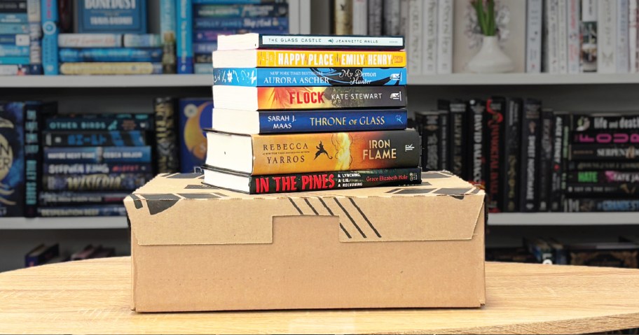 stack of books on top of a cardboard box on a table