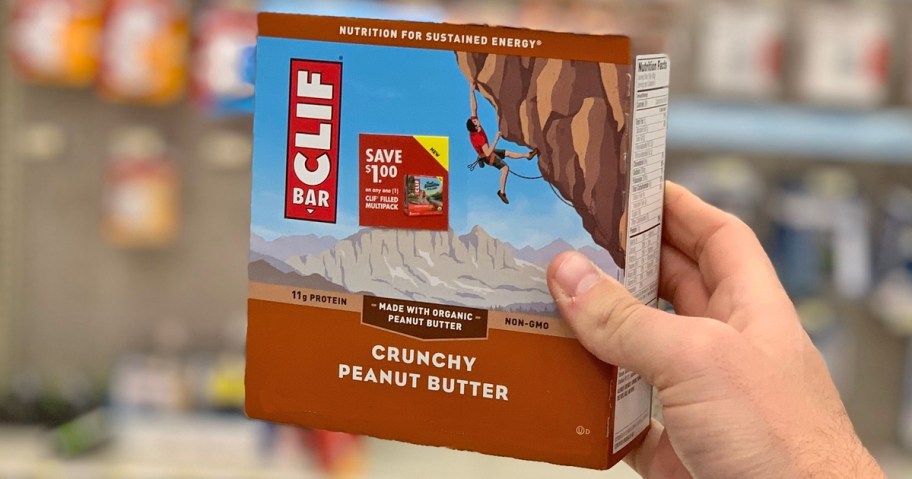 man's hand holding box of crunchy peanut butter energy bars