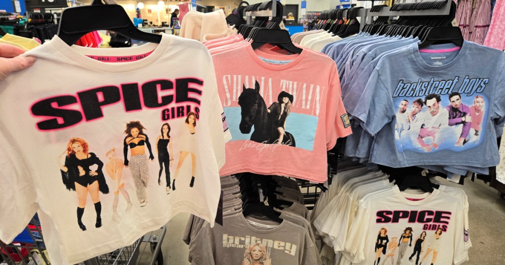 Hand holding up Spice Girls T-shirt inside Walmart store