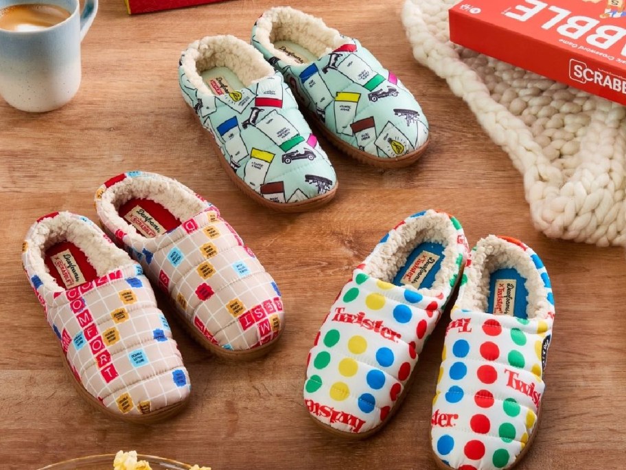 Three pairs of dearfoams slippers featuring different Hasbro board games