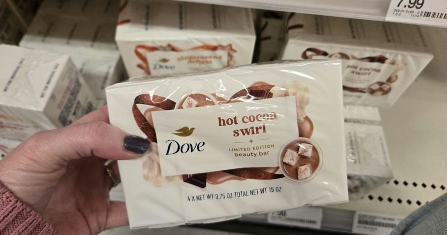 A person holding Dove beauty bars in a store