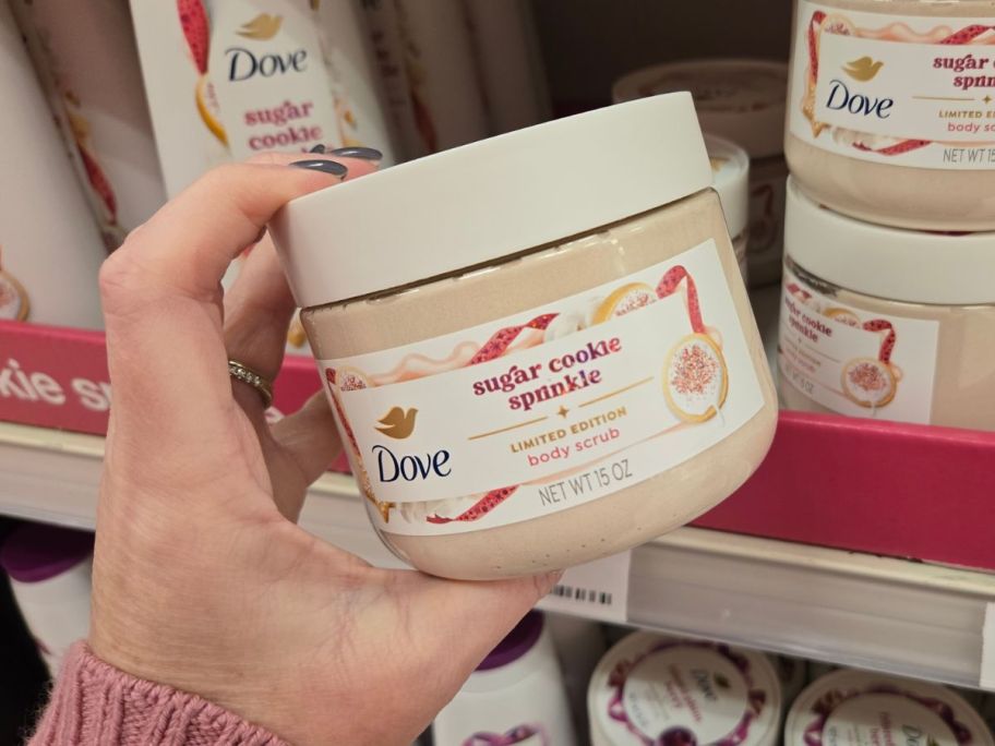 A person holding Dove body scrub in a store