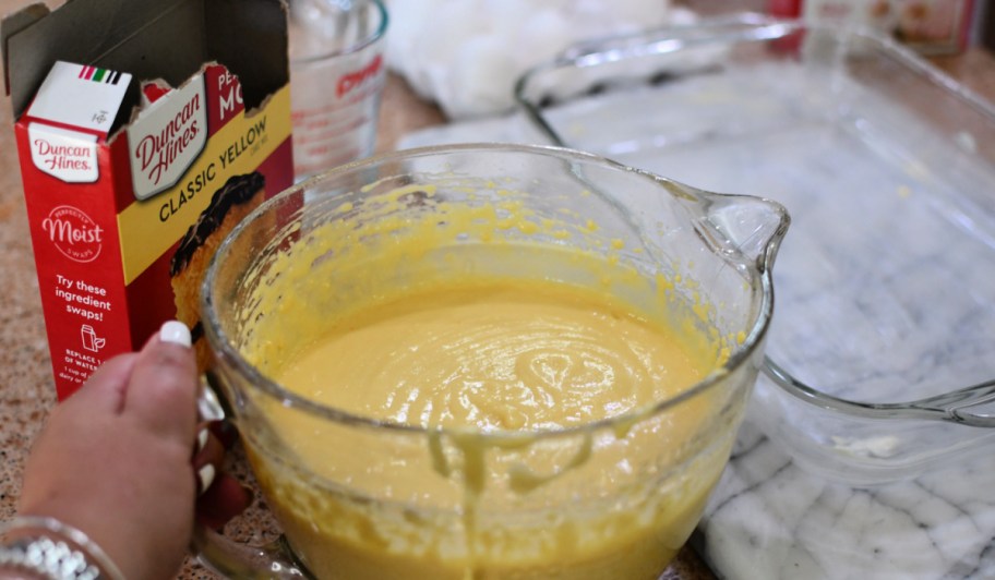 Duncan Heinz yellow cake mix on countertop next to mixing bowl filled with batter